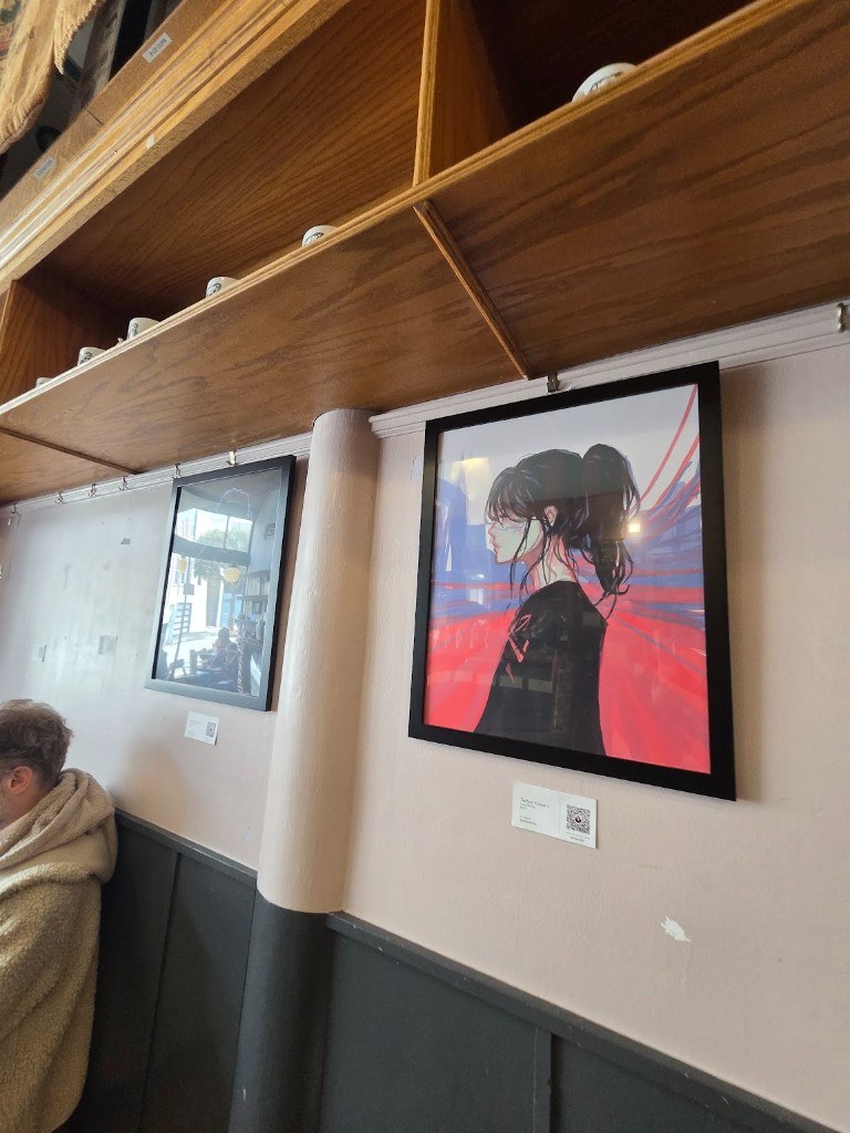 A framed portrait against a red background hanging at Spike's Coffee